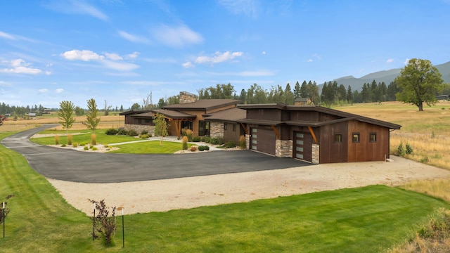 view of front facade with a mountain view, a garage, and a front yard