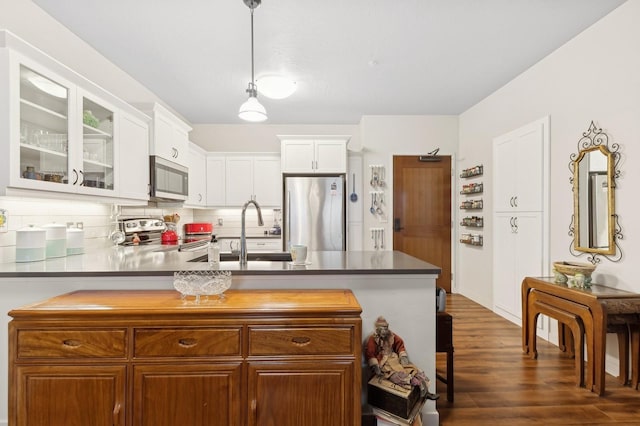 kitchen with sink, decorative light fixtures, white cabinets, stainless steel appliances, and backsplash