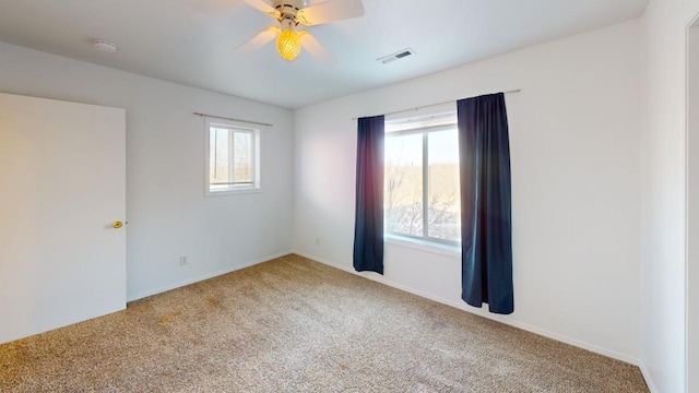 carpeted empty room featuring ceiling fan and a healthy amount of sunlight