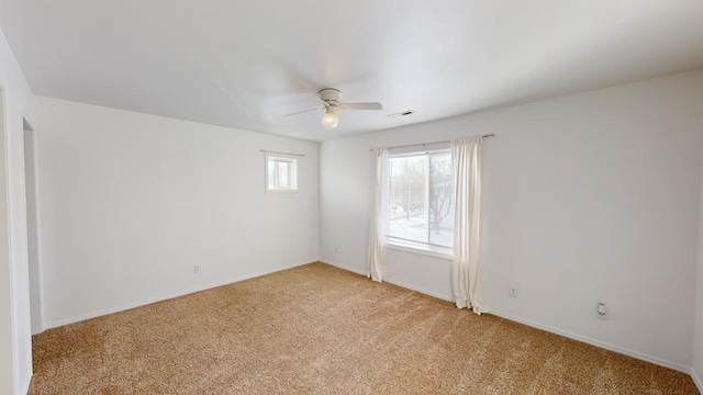 spare room with ceiling fan and light colored carpet