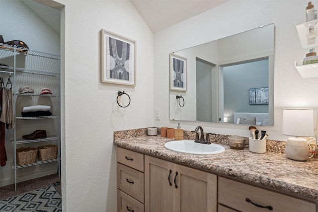 bathroom with vaulted ceiling and vanity