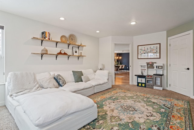 carpeted living room featuring a notable chandelier