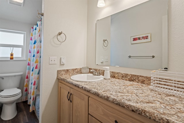 bathroom with curtained shower, hardwood / wood-style floors, toilet, and vanity