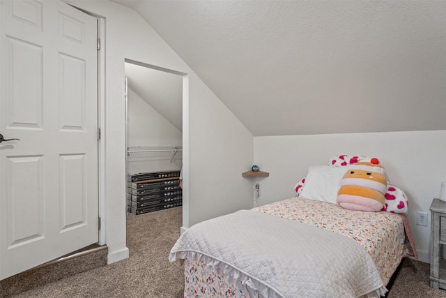 bedroom featuring a closet, vaulted ceiling, a textured ceiling, and carpet flooring