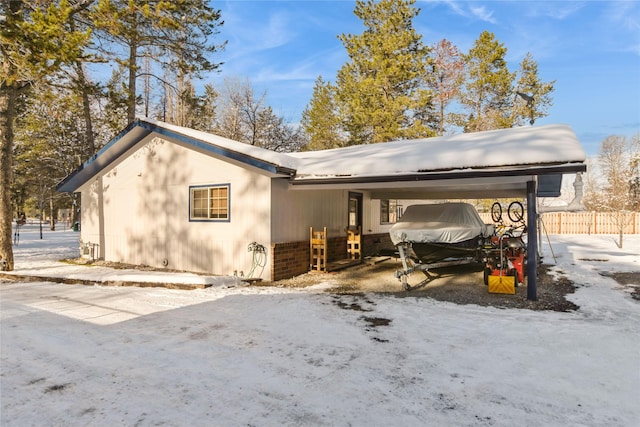 view of snowy exterior with a carport