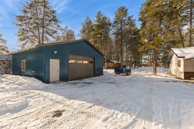 snow covered garage with a detached garage