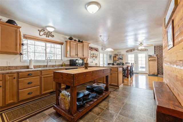 kitchen featuring a sink, a peninsula, french doors, black microwave, and a ceiling fan