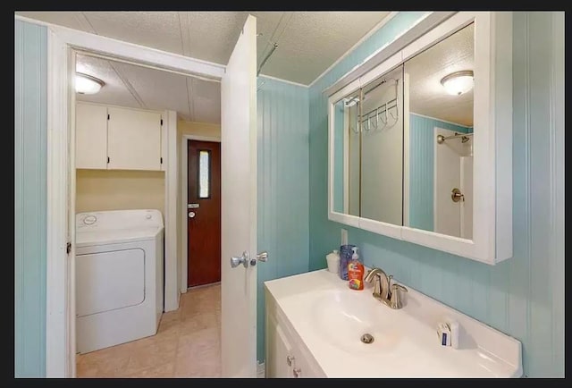 bathroom with vanity, tile patterned flooring, washer / dryer, and a textured ceiling