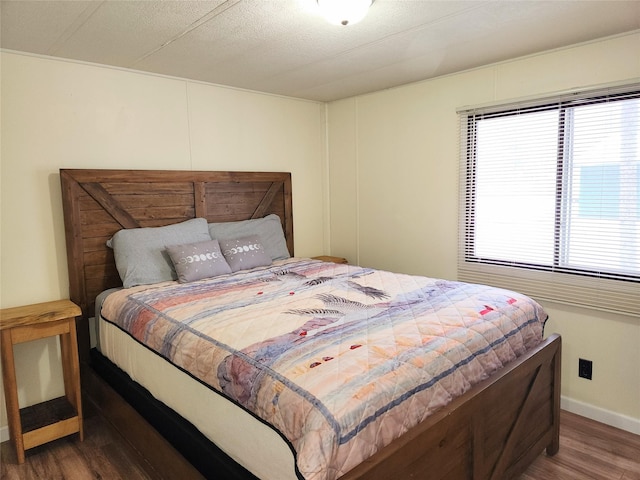 bedroom with wood finished floors and baseboards