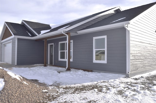 view of snowy exterior with a garage