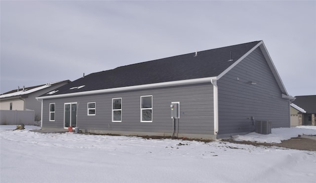 snow covered back of property with cooling unit