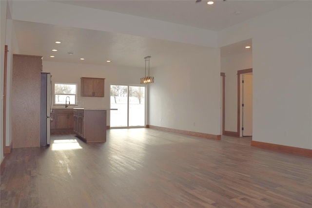 unfurnished living room featuring dark wood-type flooring and sink