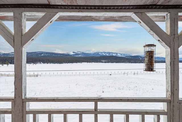 yard layered in snow featuring a mountain view