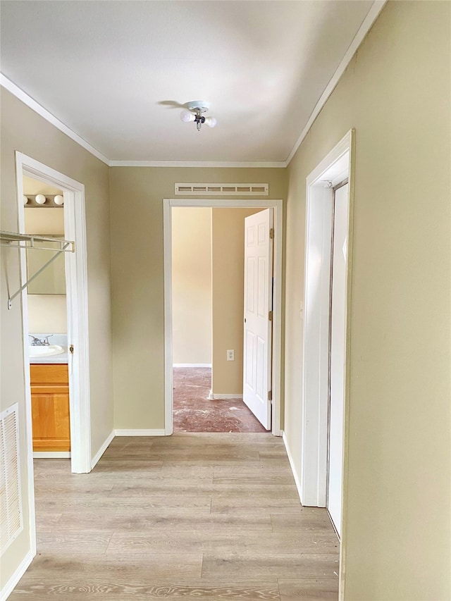 corridor featuring light hardwood / wood-style floors and ornamental molding