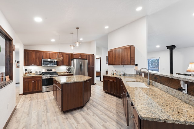 kitchen featuring a kitchen island, sink, hanging light fixtures, light stone countertops, and appliances with stainless steel finishes