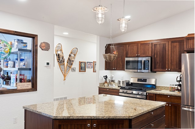 kitchen featuring pendant lighting, lofted ceiling, stainless steel appliances, and a kitchen island