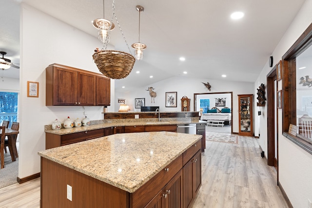 kitchen with kitchen peninsula, a kitchen island, light hardwood / wood-style floors, and pendant lighting