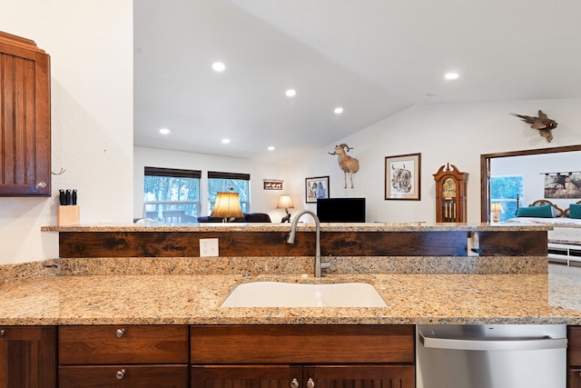 kitchen featuring vaulted ceiling, light stone countertops, dishwasher, and sink