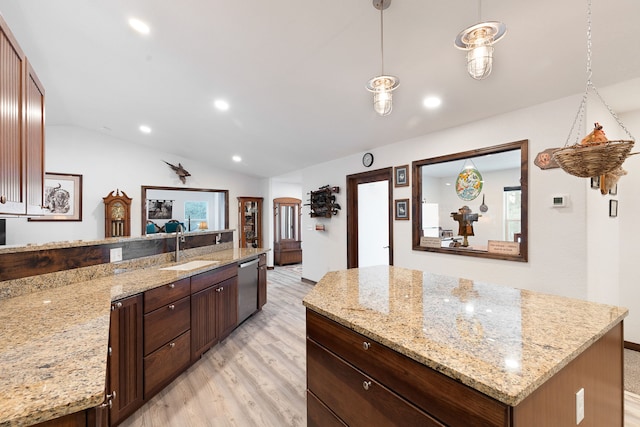 kitchen featuring lofted ceiling, dishwasher, a kitchen island, hanging light fixtures, and light stone countertops