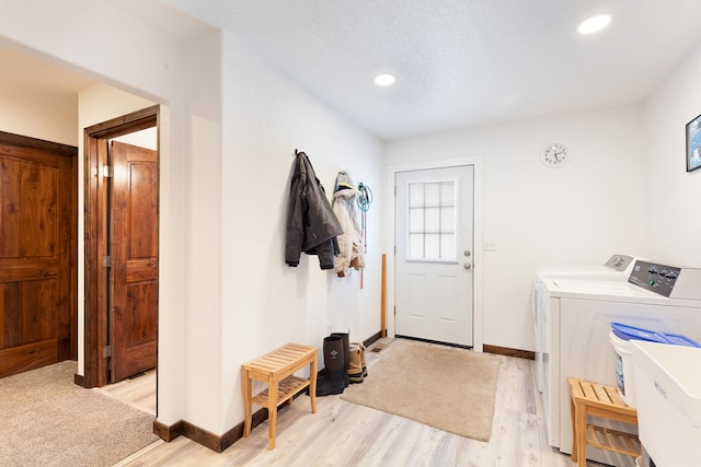 laundry room with washer and dryer, light hardwood / wood-style floors, and sink