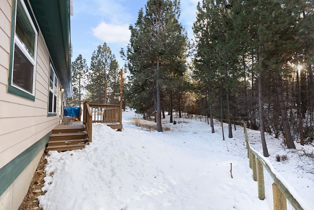 yard covered in snow featuring a wooden deck