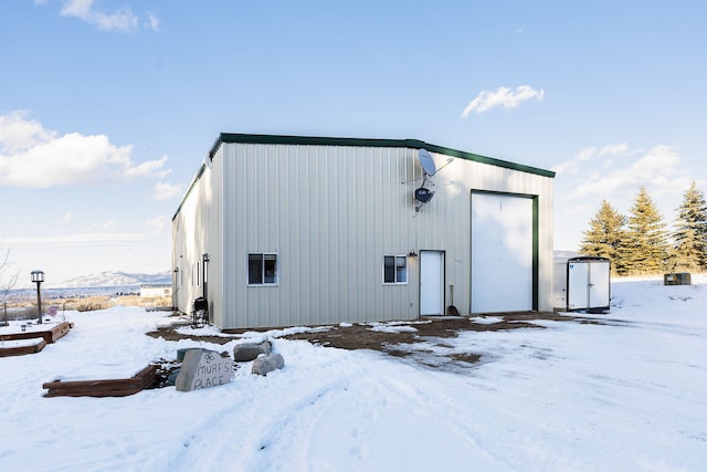 snow covered structure with a mountain view