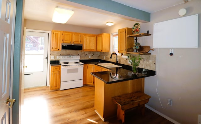 kitchen with kitchen peninsula, sink, white electric range oven, tasteful backsplash, and light hardwood / wood-style floors