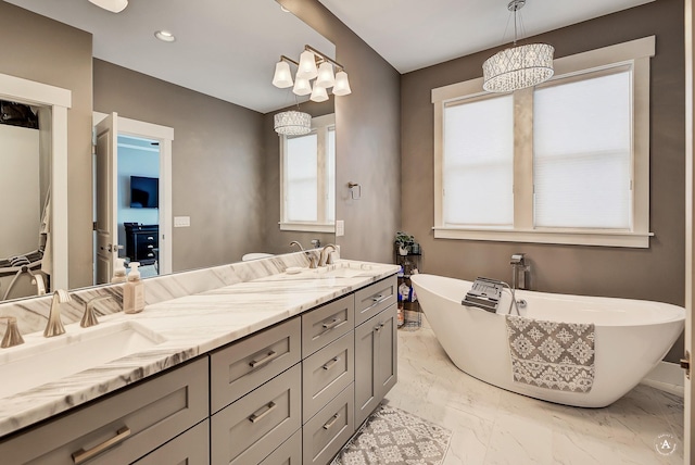 bathroom with a washtub, vanity, and a notable chandelier