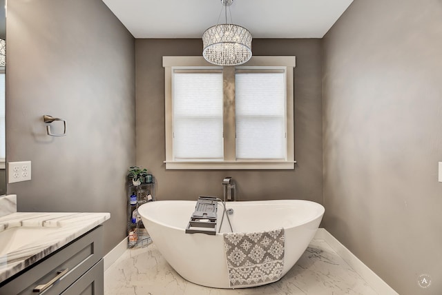 bathroom featuring vanity, a chandelier, and a tub