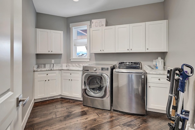 washroom featuring cabinets, washer and clothes dryer, and dark hardwood / wood-style flooring