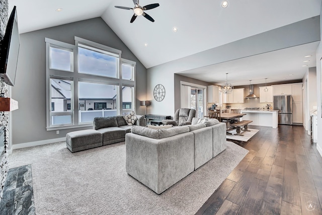 living room featuring high vaulted ceiling, wood-type flooring, and ceiling fan with notable chandelier