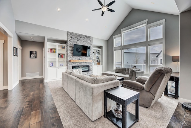 living room featuring hardwood / wood-style floors, ceiling fan, built in features, a fireplace, and high vaulted ceiling