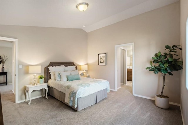 carpeted bedroom featuring ensuite bathroom and vaulted ceiling