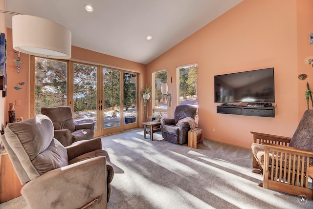 carpeted living room featuring high vaulted ceiling and french doors