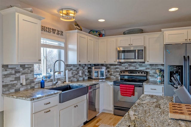 3761 Aster St, East Helena, MT 59635 - kitchen with a sink, white cabinets, light stone counters, and stainless steel appliances
