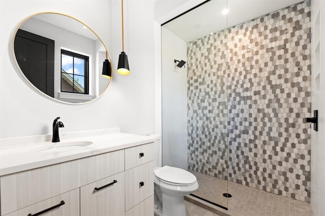 bathroom with vanity, toilet, and a tile shower