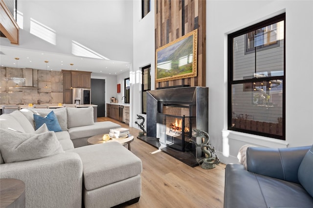 living room with a high ceiling and light wood-type flooring