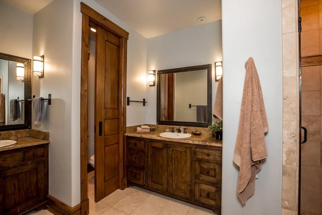 bathroom featuring vanity, toilet, a shower with shower door, and tile patterned flooring