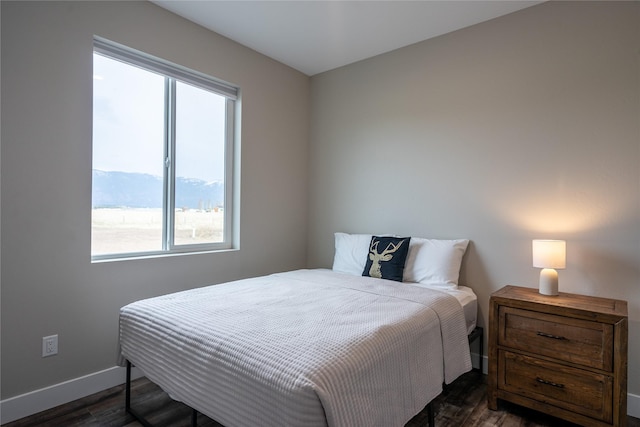 bedroom featuring a mountain view and dark hardwood / wood-style flooring