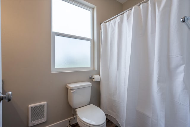 bathroom featuring toilet and heating unit