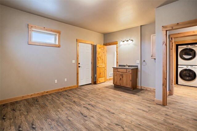 interior space with toilet, vanity, and stacked washer and dryer