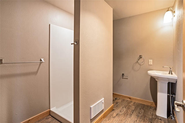 full bathroom featuring baseboards, visible vents, wood finished floors, and a sink