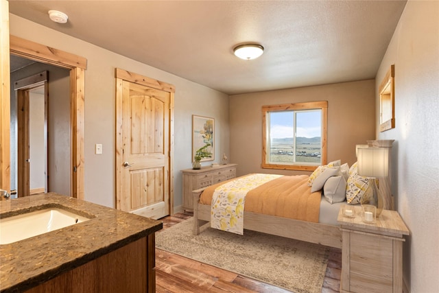 bedroom with a sink and wood finished floors