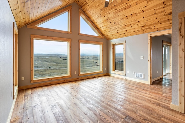 spare room with light wood finished floors, visible vents, and a healthy amount of sunlight