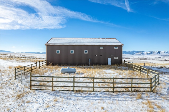 snow covered back of property with a mountain view