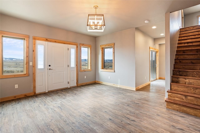 foyer entrance featuring a wealth of natural light, a chandelier, and wood-type flooring