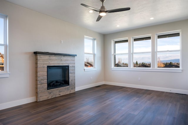 unfurnished living room featuring ceiling fan, dark hardwood / wood-style flooring, and a fireplace