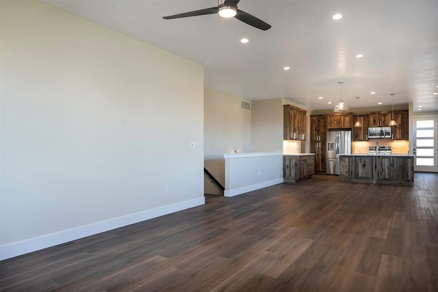 unfurnished living room featuring ceiling fan and dark hardwood / wood-style floors