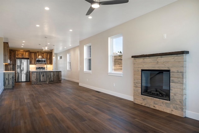 unfurnished living room featuring ceiling fan and dark hardwood / wood-style floors