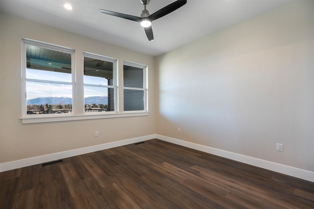 empty room with ceiling fan and dark hardwood / wood-style floors